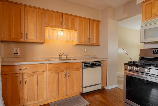 kitchen with dark hardwood / wood-style flooring, sink, and white appliances