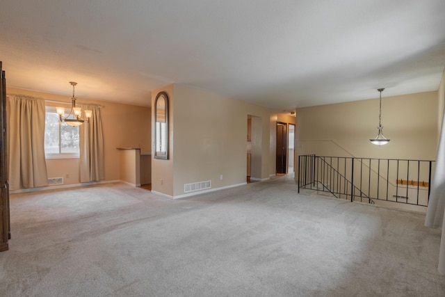 empty room featuring an inviting chandelier and light carpet
