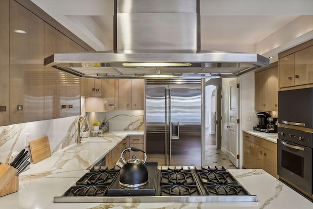 kitchen with appliances with stainless steel finishes, sink, decorative backsplash, and range hood