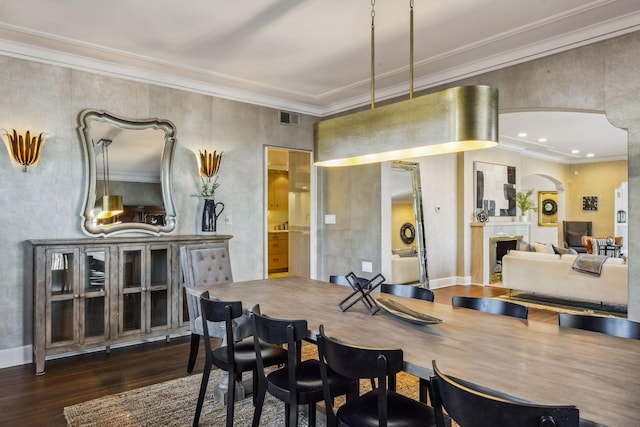 dining space featuring ornamental molding and dark hardwood / wood-style floors