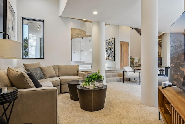 living room with ornate columns and light colored carpet