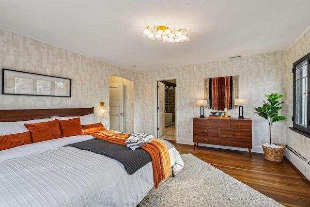 bedroom with dark hardwood / wood-style floors and baseboard heating