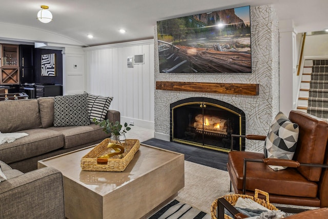 living room featuring wood-type flooring, lofted ceiling, and a fireplace