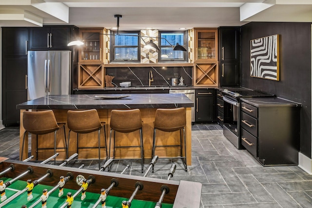 bar with pendant lighting, sink, backsplash, and stainless steel appliances