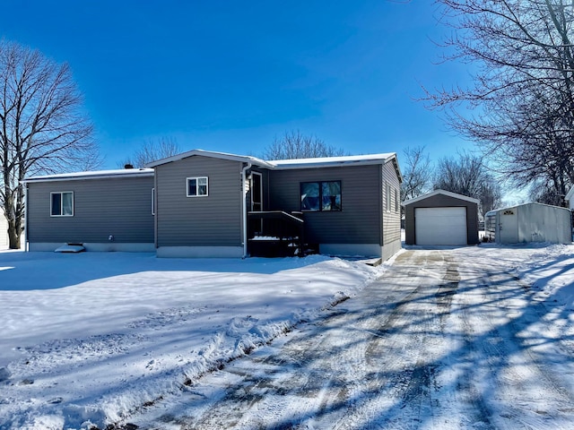 manufactured / mobile home featuring a garage, driveway, and an outdoor structure