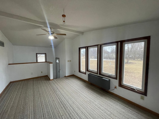 spare room featuring vaulted ceiling with beams, ceiling fan, carpet flooring, baseboards, and radiator