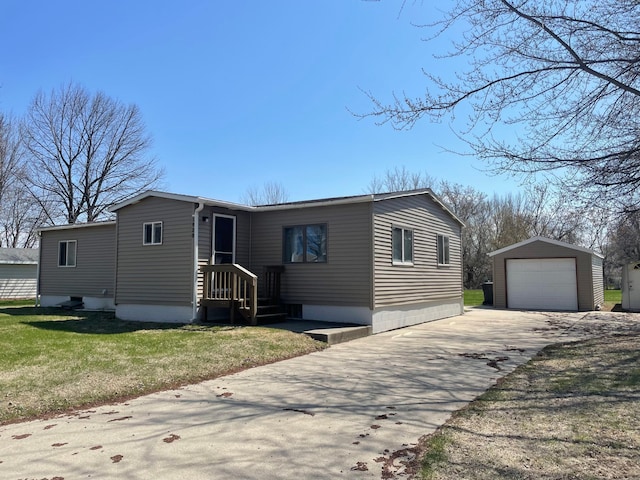 1920 Spruce Ave, Worthington, MN 56187 - manufactured / mobile home featuring concrete driveway, an outdoor structure, a detached garage, and a front lawn