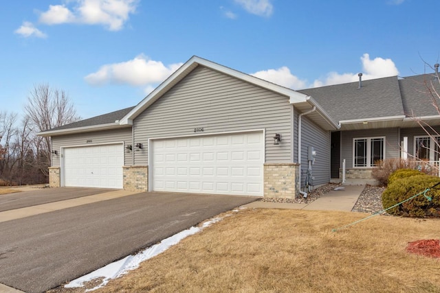 ranch-style home featuring a garage and a front lawn