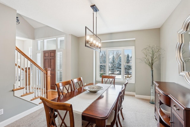 carpeted dining room with a chandelier