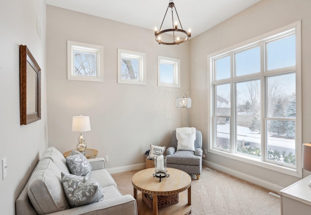 living area with an inviting chandelier and carpet