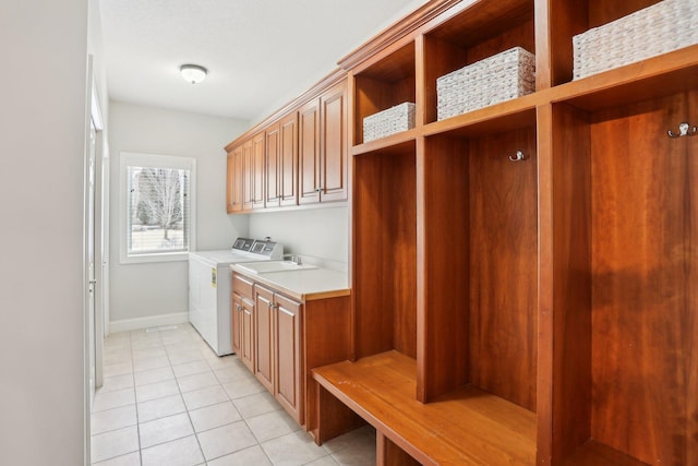 mudroom with light tile patterned floors and washing machine and clothes dryer