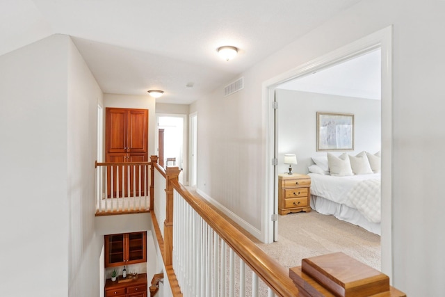 hallway featuring light colored carpet