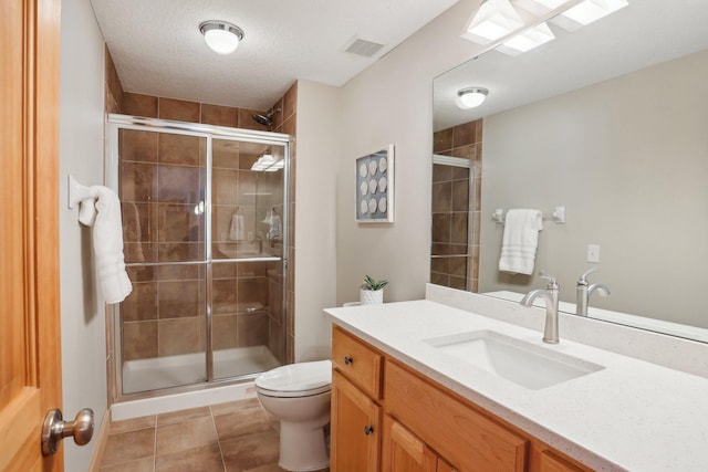 bathroom with tile patterned floors, toilet, an enclosed shower, a textured ceiling, and vanity