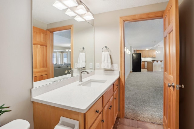 bathroom with tile patterned floors, vanity, and a textured ceiling