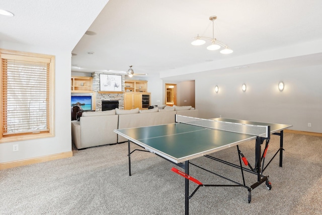 playroom featuring light carpet, a fireplace, and ceiling fan