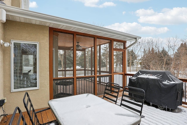 snow covered deck featuring a sunroom and a grill