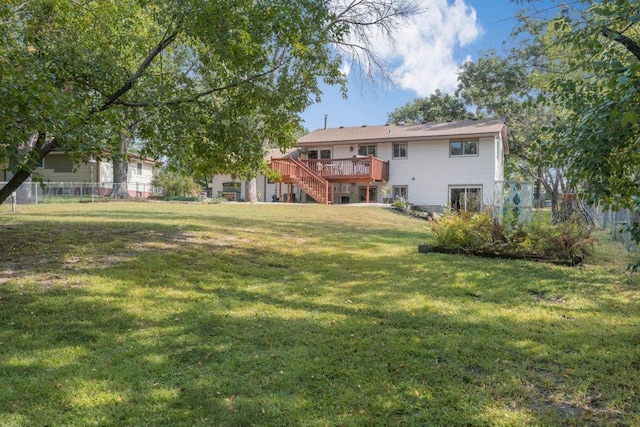 back of house featuring a wooden deck and a lawn