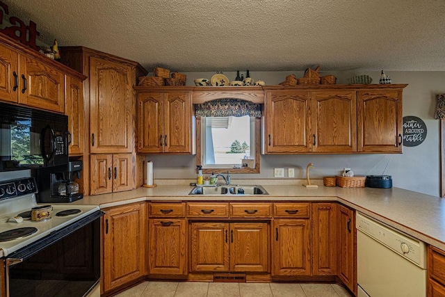 kitchen featuring dishwasher, sink, light tile patterned floors, electric range, and a textured ceiling