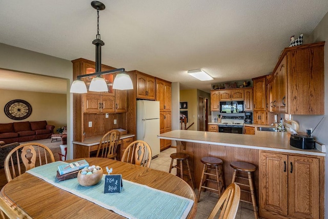 dining area featuring sink and light tile patterned floors