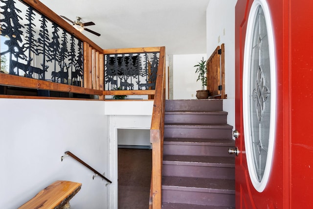 stairway featuring ceiling fan