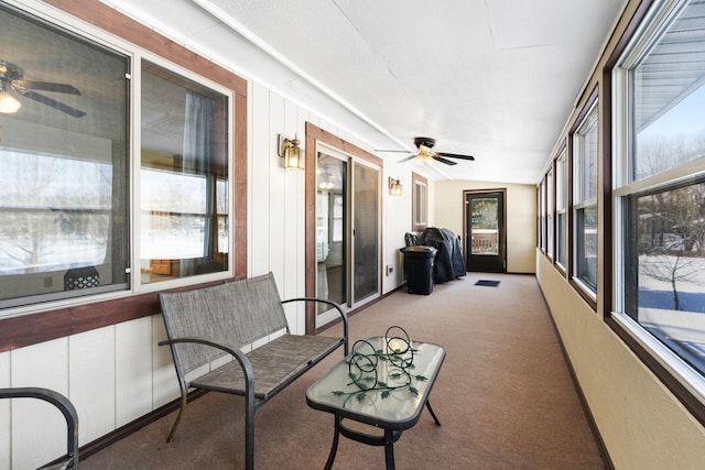 sunroom featuring plenty of natural light, carpet, and ceiling fan