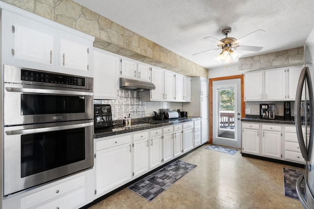 kitchen featuring a ceiling fan, tasteful backsplash, under cabinet range hood, stainless steel appliances, and white cabinets