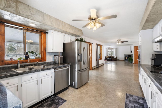 kitchen featuring ceiling fan, a sink, tile countertops, and appliances with stainless steel finishes