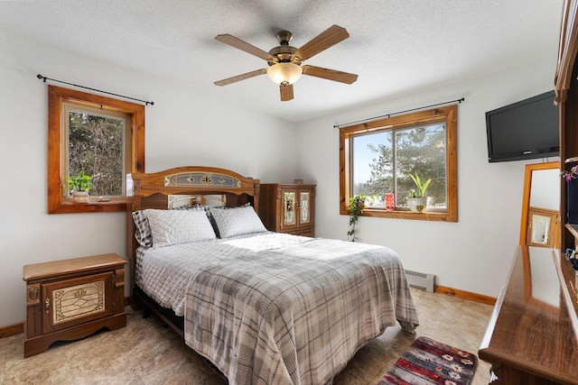 bedroom with a baseboard radiator, a ceiling fan, baseboards, and a textured ceiling