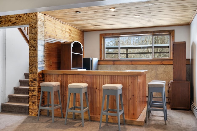 bar with a dry bar, a baseboard radiator, wooden ceiling, and carpet floors