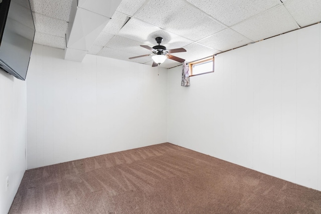 carpeted spare room featuring a drop ceiling