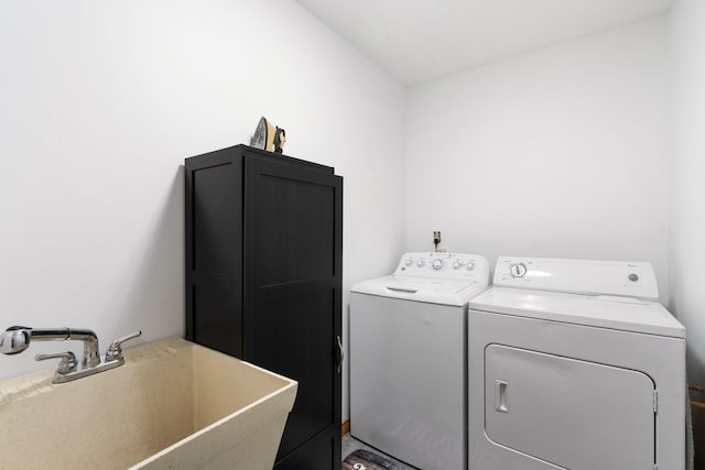 clothes washing area featuring independent washer and dryer and a sink