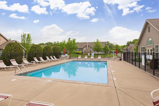 community pool with a patio and fence