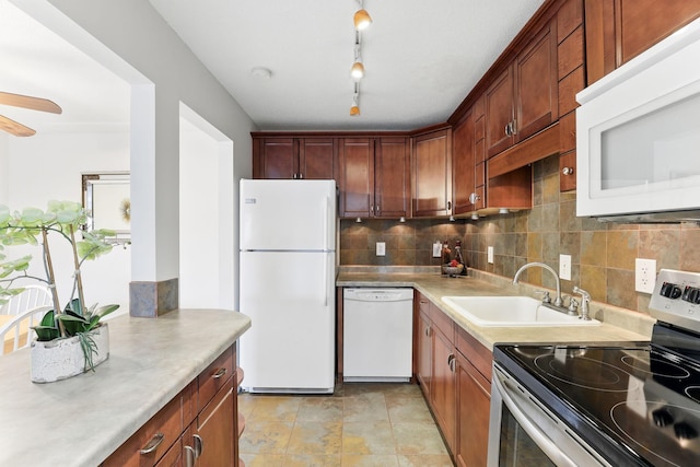 kitchen featuring ceiling fan, light countertops, decorative backsplash, white appliances, and a sink