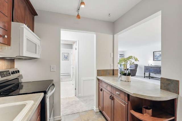 kitchen featuring light countertops, electric stove, white microwave, and baseboard heating