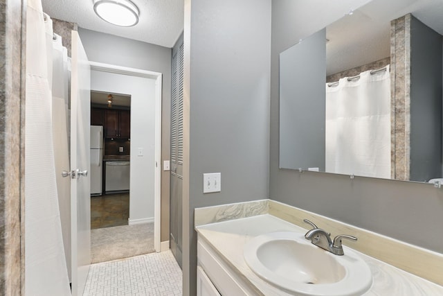 full bath featuring vanity, a shower with curtain, and a textured ceiling