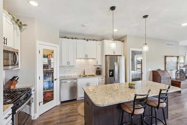 kitchen with stainless steel appliances, dark wood finished floors, visible vents, and a sink