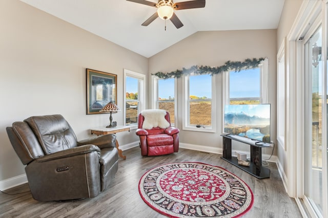 sitting room featuring plenty of natural light, baseboards, vaulted ceiling, and wood finished floors