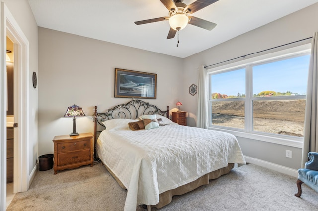 bedroom with light carpet, ceiling fan, and baseboards