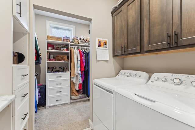 clothes washing area featuring light carpet, separate washer and dryer, and cabinet space