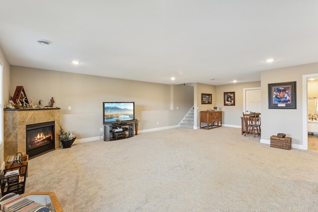 carpeted living area featuring recessed lighting, baseboards, a tiled fireplace, and stairs