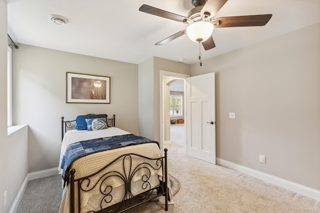 bedroom featuring carpet, arched walkways, and baseboards