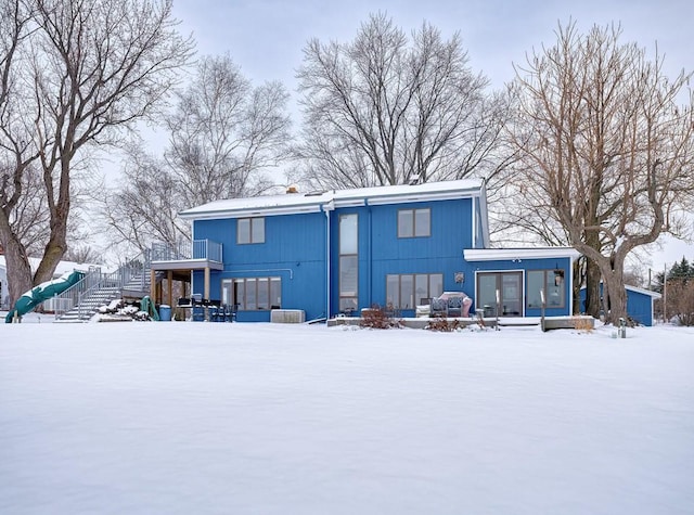 snow covered rear of property with a chimney