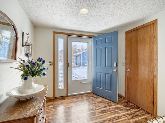 entryway with a textured ceiling, baseboards, and dark wood-style flooring