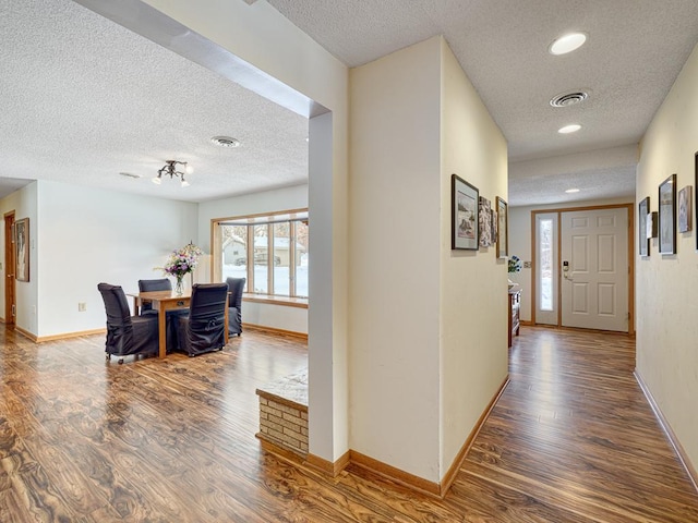 entryway featuring wood finished floors, visible vents, and baseboards