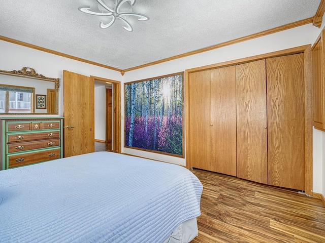 bedroom with a textured ceiling, ornamental molding, and light wood-type flooring