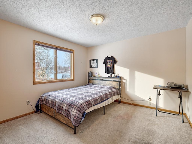 bedroom with light carpet, a textured ceiling, and baseboards