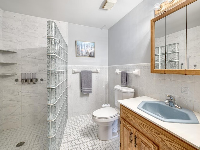 full bathroom with a wainscoted wall, tile walls, toilet, vanity, and walk in shower