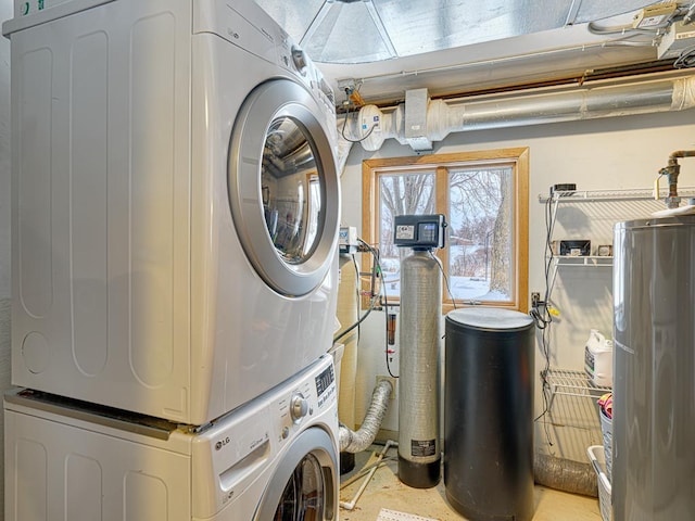 laundry area featuring water heater, laundry area, and stacked washing maching and dryer