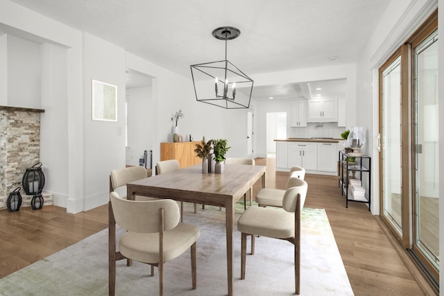 dining room with a notable chandelier and light wood-type flooring