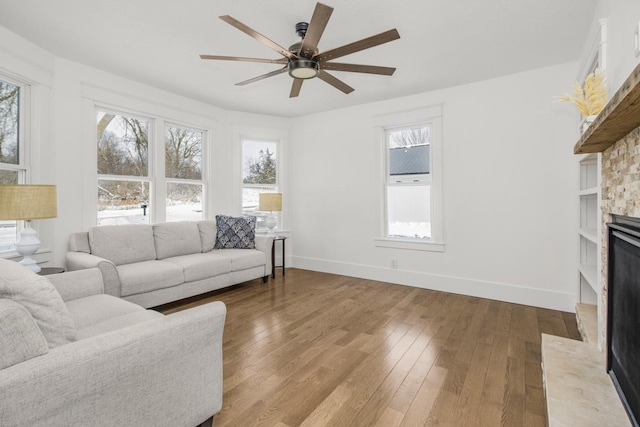 living room with plenty of natural light, ceiling fan, and light hardwood / wood-style flooring